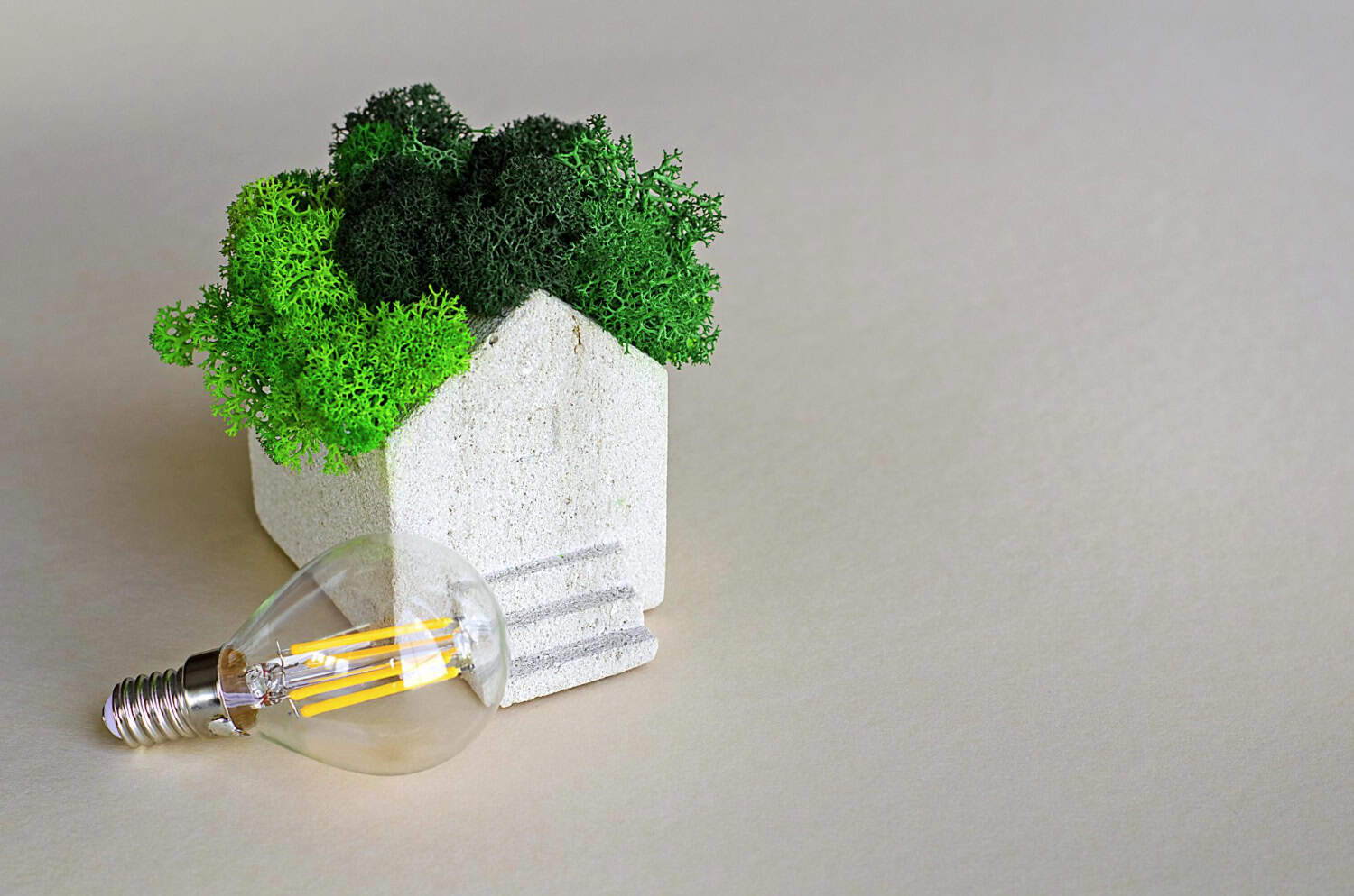 Obrazek przedstawia model eco-domu, który nawiązuje do przydomowe magazyny energii. Dzięki niemu, dom staje się energooszczędny.